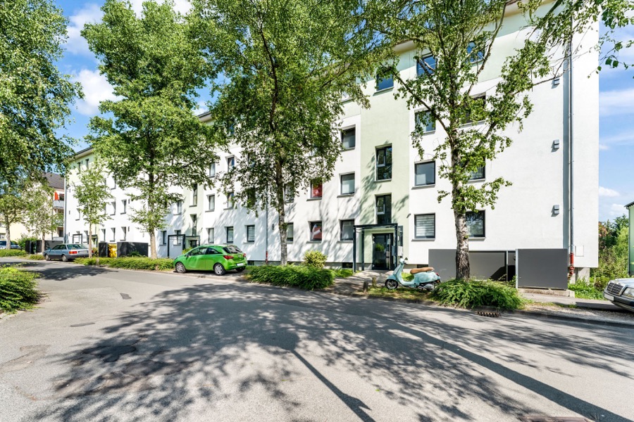 Weißes Mehrfamilienhaus im Grünen